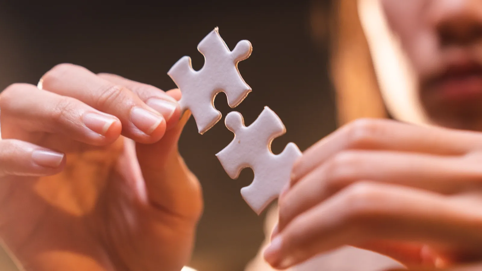 Woman connecting puzzle pieces while working through a solution