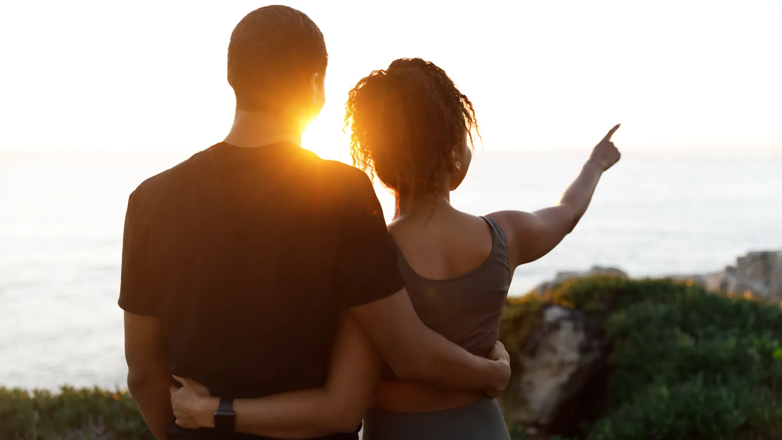 Couple embracing while looking out over the water