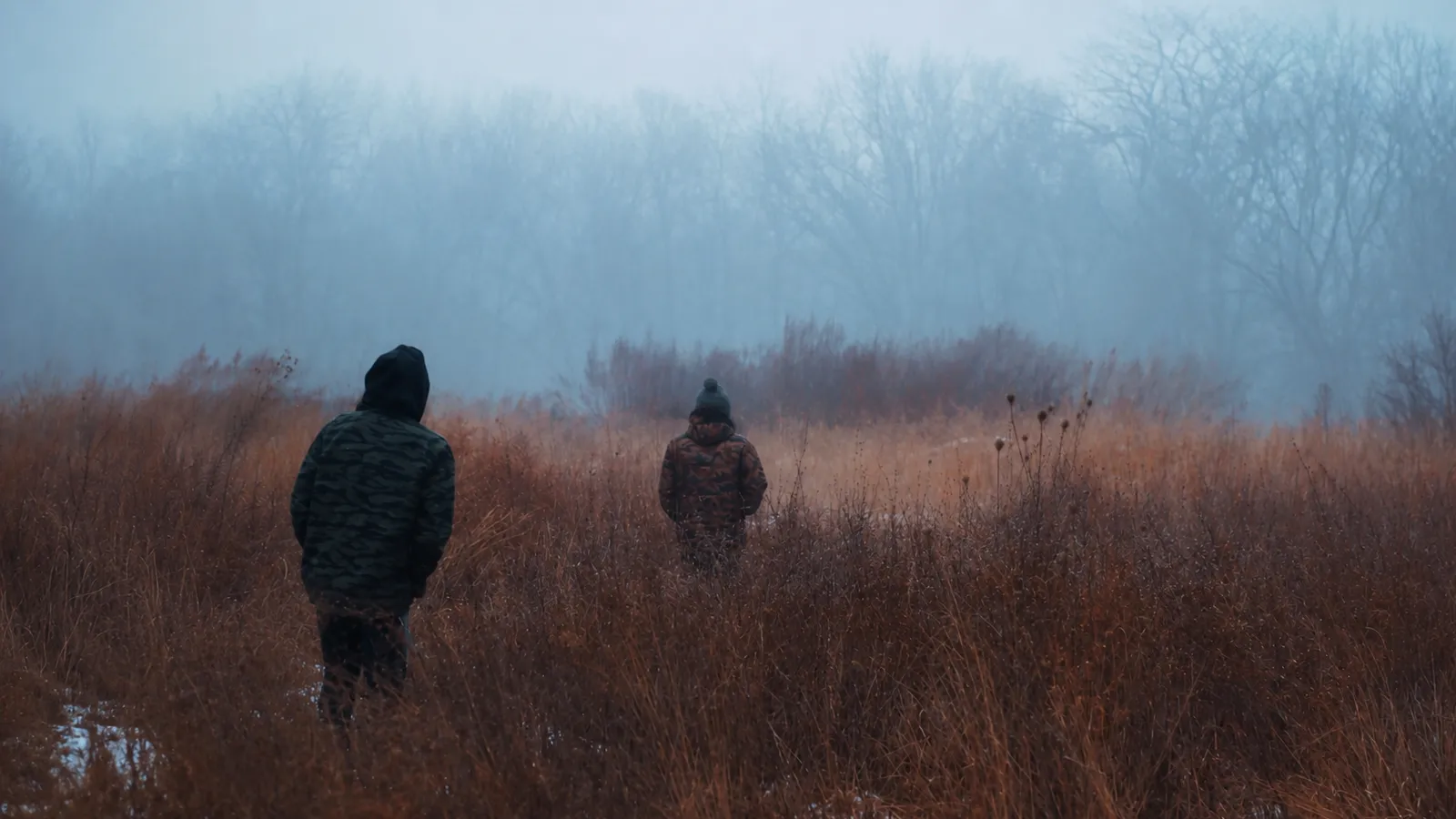 Two people walking separately through a foggy field, symbolizing emotional distance and the importance of seeing people with dignity.